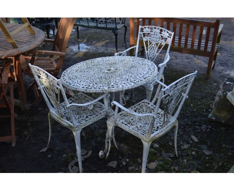 A CIRCULAR WHITE GROUND ALUMINIUM GARDEN TABLE, (broken leg) and three matching armchairs (4)