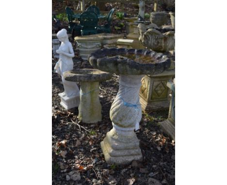 A COMPOSITE SHELL TOPPED BIRD BATH, height 82cm, together with a smaller composite bird bath and an alabaster semi clad woman