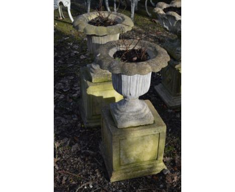 A PAIR OF COMPOSITE TULIP STYLE GARDEN URNS, on a separate cubed plinth, diameter 45cm overall x height 58cm x height of top 