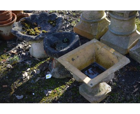 A COMPOSITE OYSTER TOPPED BIRD BATH, on a separate base, together with a similar smaller bird bath and a clay square tapering
