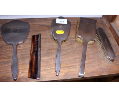 A silver backed three-piece dressing table set and a similar brush and comb set 