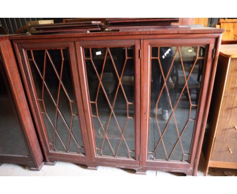 A mahogany bookcase enclosed three lattice doors, on bracket feet, 62" wide, a mahogany bookcase enclosed central lattice gla