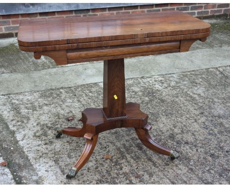 A Regency rosewood fold-over top card table, on central faceted column and quadruple splay supports with castored lion paw te