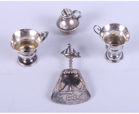 A Dutch silver caddy spoon, decorated boating scenes, import marks Burthold Muller, two miniature cups and a pepperette, in t