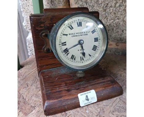 A VINTAGE DASHBOARD CLOCK BY NICOLE NIELSEN &amp; CO LTD MOUNTED ON A WOODEN STAND