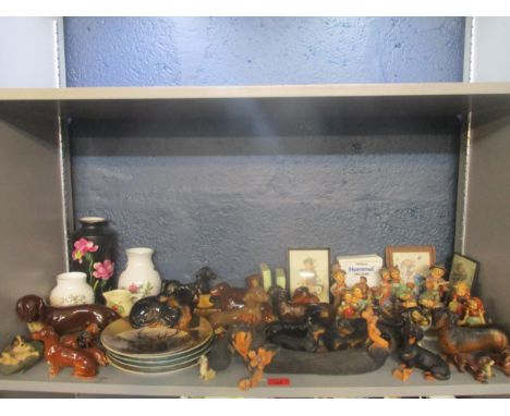 A collection of Goebel Hummel figurines, pictures and a collectors field guide, a collection of Dachshund ceramic model dogs 