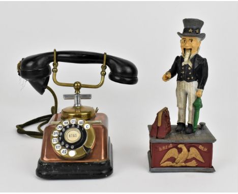 A vintage copper and Bakelite phone with rotary dial, together with a painted iron Uncle Sam mechanical money box, the box 29