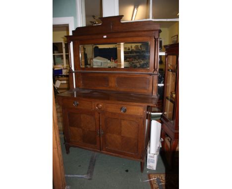 An arts and crafts Oak mirror back Sideboard, having applied moulded pediment top over moulded cornice and rectangular bevel 