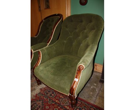 A Victorian salon Armchair in green velvet button back upholstery, with carved ends to the arms and standing on turned legs.