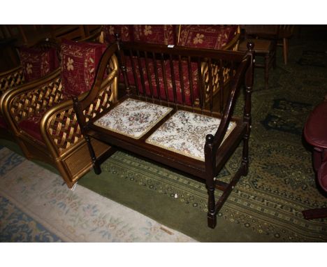 A stained Beech stick back Bench Seat having tapestry seat, and standing on turned legs.