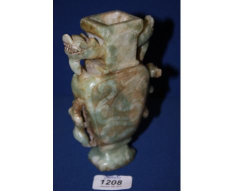 An oriental carved jade two handled Vase, the handles being carved temple dogs, and carved stalking tigers below.  6'' tall