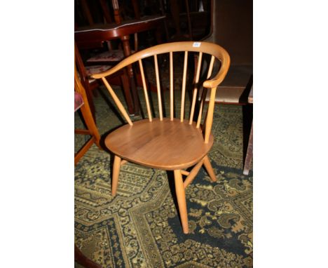 An Ercol Golden Dawn Elbow Chair, shaped top rail on stick back, shaped seat, standing on turned legs with stretchers.
