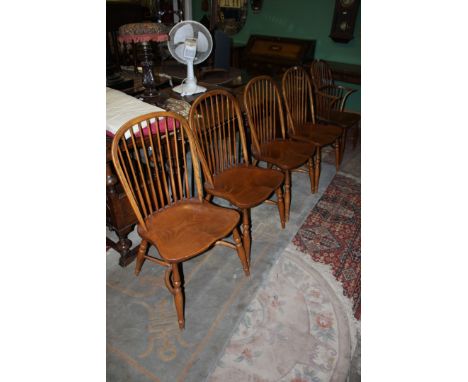 A set of four reproduction good quality stick back country style Dining Chairs having shaped elm seats, standing on turned le
