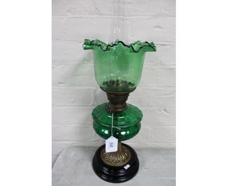 A Victorian brass oil lamp on wooden base with green glass reservoir and shade   CONDITION REPORT: A couple of tiny chips to 