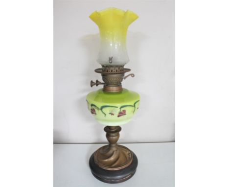 A Victorian oil lamp with hand painted glass reservoir and two tone glass shade 