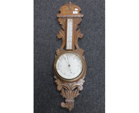 An Edwardian carved oak cased barometer by R Rosmond of Leicester 