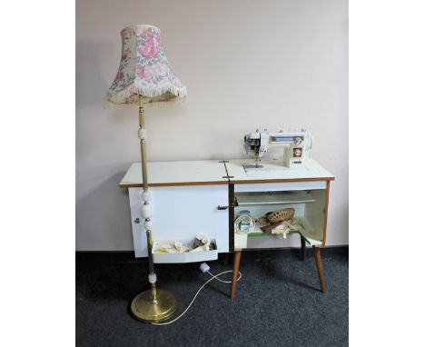 A 20th century Newhome electric sewing machine in cabinet and a standard lamp &amp; shade 