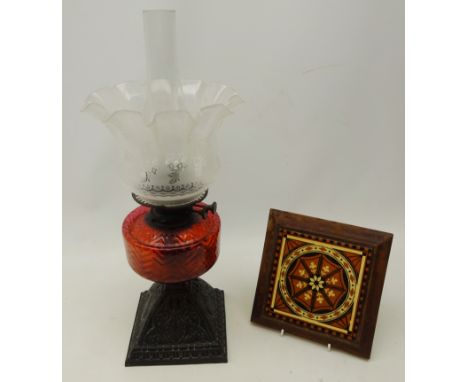 Victorian oil lamp with pierced cast metal base, ruby glass well and glass shade, H54cm including funnel and a Victorian tile