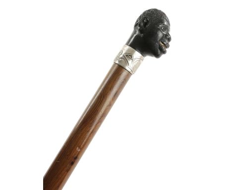 A LATE VICTORIAN WALKING STICKC.1890-1900the ebony finial in the form of a male blackamoor's head with glass eyes and bone te
