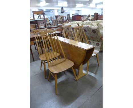 An Ercol Blonde elm and beech drop leaf dining table and a set of four Goldsmith chairs 