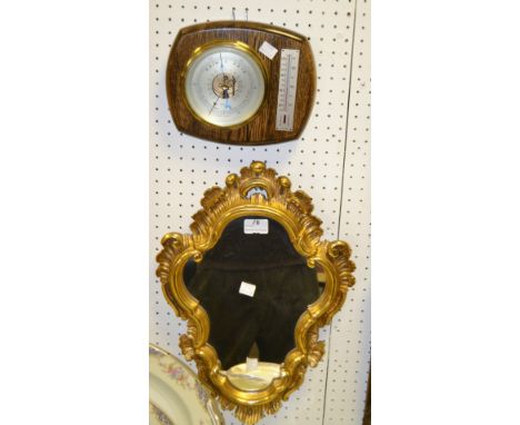 A gilt Rococo style framed mirror; an oak barometer