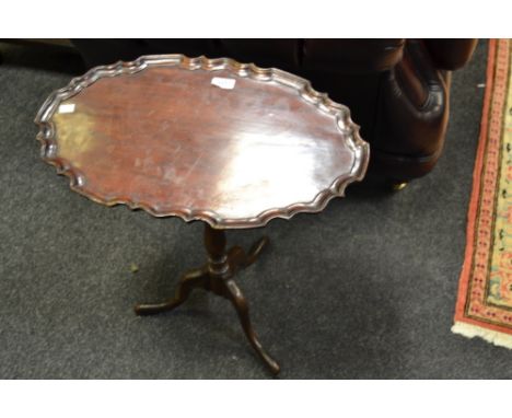 A Chippendale Revival mahogany shaped oval tilt-top tripod occasional table, piecrust edge, turned column, cabriole legs, ear
