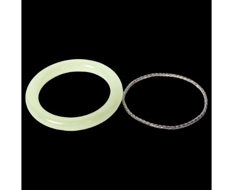 A green jadeite bangle, diameter 78mm, inside diameter 55mm, and a spiral bangle (2) 