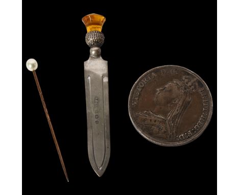 An unmarked gold stickpin, surmounted by a pearl, a silver thistle design bookmark, and a Victorian crown 1890 
