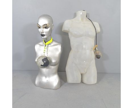 A female mannequin torso with decorated face and ball & chain necklace, and a back-lit opaque plastic male torso.Not seen wor