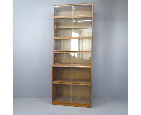 A mid-century teak six tier sectional bookcase by Simplex, each shelf having sliding glass doors. Overall 92x232x36cm. 