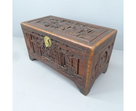 A Chinese camphorwood trunk with all-over carved decoration and tray fitted interior. 102x86x51cm 