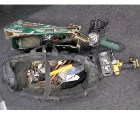 A plumber's bag containing brass fittings together with a Bosch sander, grinder, De Walt drill, cased drill bits 