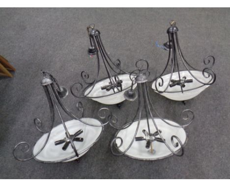Four contemporary wrought iron hanging light fittings with opaque glass shades  