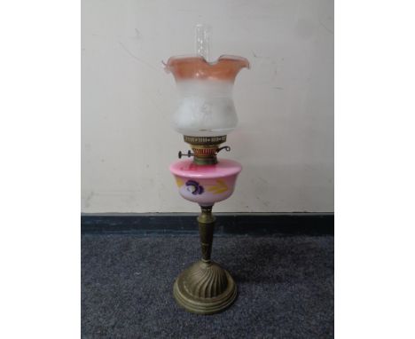 An antique brass oil lamp with hand painted glass reservoir, chimney and shade  