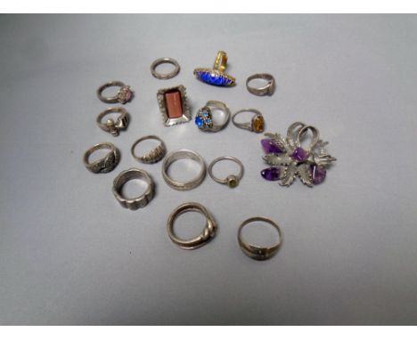 A box of a collection of silver and costume rings and a costume brooch  