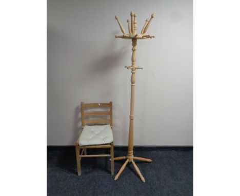 A stripped pine hat and coat stand together with a pine ladder back rush seated kitchen chair  