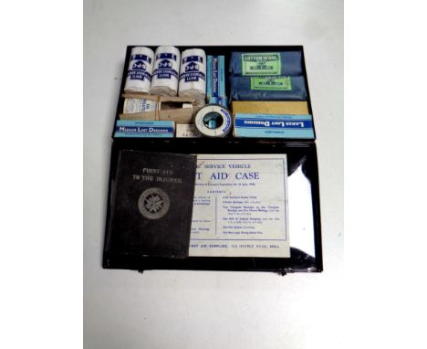 A vintage first aid tin with contents, together with a first aid book  