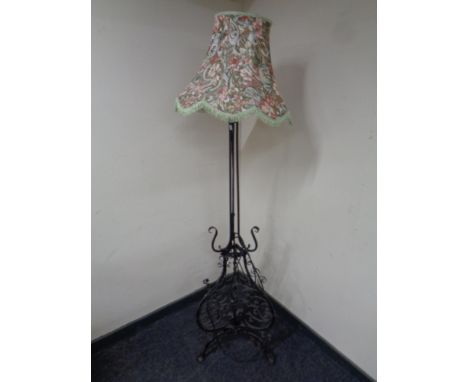 A wrought iron standard lamp with shade  