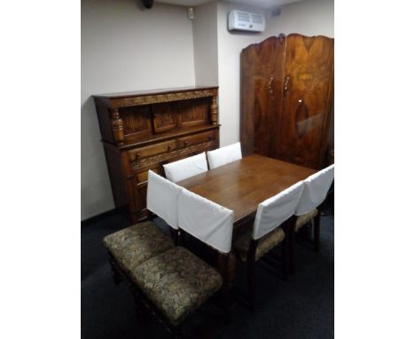A carved oak refectory extending dining table and bulbous legs and a set of six tapestry upholstered chairs 