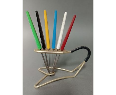 A vintage gilt metal knife stand with rubber bound handle and six multi-coloured plastic handled knives, the steel blades unm