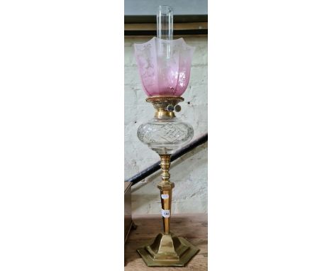 A Victorian brass oil lamp with cut glass reservoir and pink etched glass shade.Condition:- General wear to brass through age