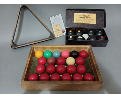 A set of vintage snooker balls and a triangle, together with a cased set of carpet bowls. 