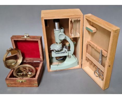 A vintage boxed Regent student microscope with few accessories and a reproduction Natural Sine brass compass in wooden case. 