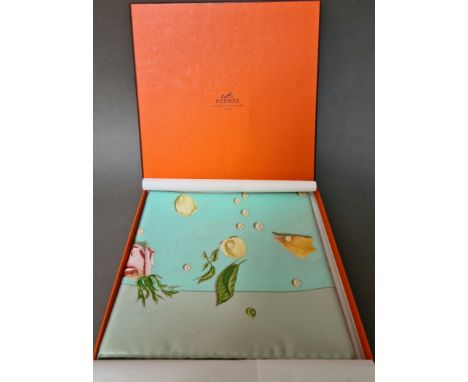A Hermes "Roses" silk scarf, having various coloured roses on a light blue background, label attached, with original box.Cond