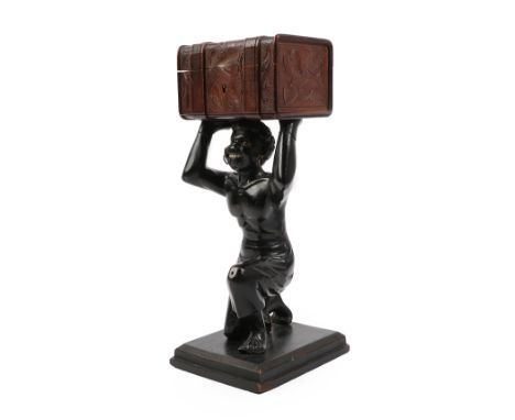 A Carved and Painted Figural Business Card Holder, as a kneeling blackamoor holding a travelling trunk, on a stepped rectangu