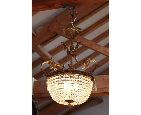 A Gilt Metal and Cut Glass Chandelier, in 18th century style, with wrythen column, scroll supports and foliate mounted circul