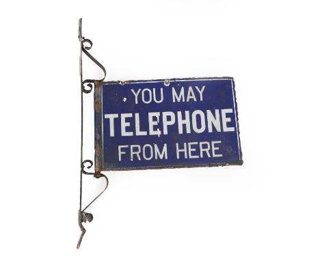 A Double-Sided Enamel Sign, inscribed YOU MAY TELEPHONE FROM HERE, 30cm by 46cm, with wrought-iron bracket