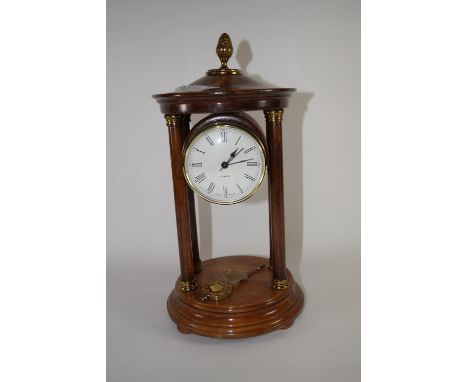 Quartz clock in wooden case, supported by four wooden pillars, with brass acorn knop, 27cm high