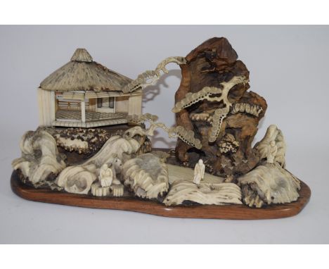 Intricate Japanese diorama depicting a mountainous landscape with pavilions and figures in wood, antler, ivory and bone on or