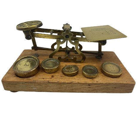 Set of brass postal scales by S Mordan &amp; Co on an oak plinth and five brass weights